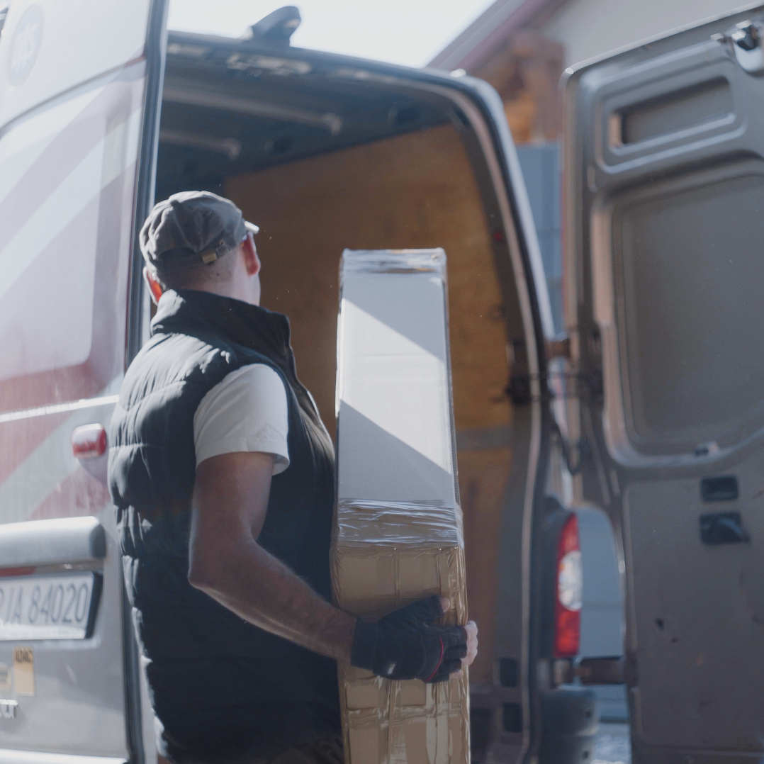 Ein Mitarbeiter verpackt ein Paket in einen Lieferwagen